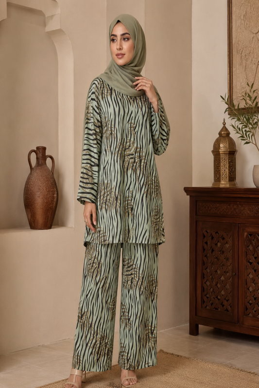 Woman wearing a green and black zebra print outfit in a room with decorative elements.